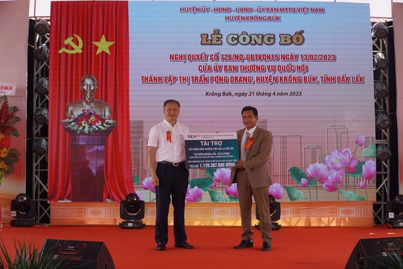 Đại diện Ngân hàng BIDV Chi nhánh Buôn Hồ trao bảng tài trợ xây dựng điểm trường cho lãnh đạo huyện Krông Búk.