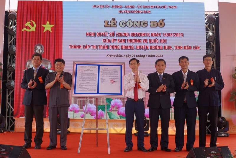 Phó Bí thư Thường trực Tỉnh ủy Phạm Minh Tấn (thứ 2 từ trái sang) trao Nghị Quyết thành lập thị trấn Pơng Drang cho lãnh đạo địa phương.