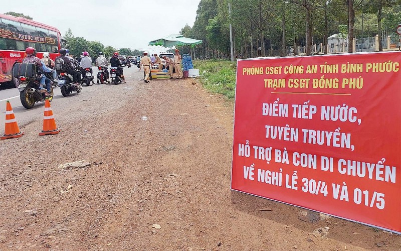 CSGT Bình Phước tặng nước mát và khăn lạnh cho người dân di chuyển trên QL14 qua địa bàn tỉnh Bình Phước. Ảnh: Đức Hiển.