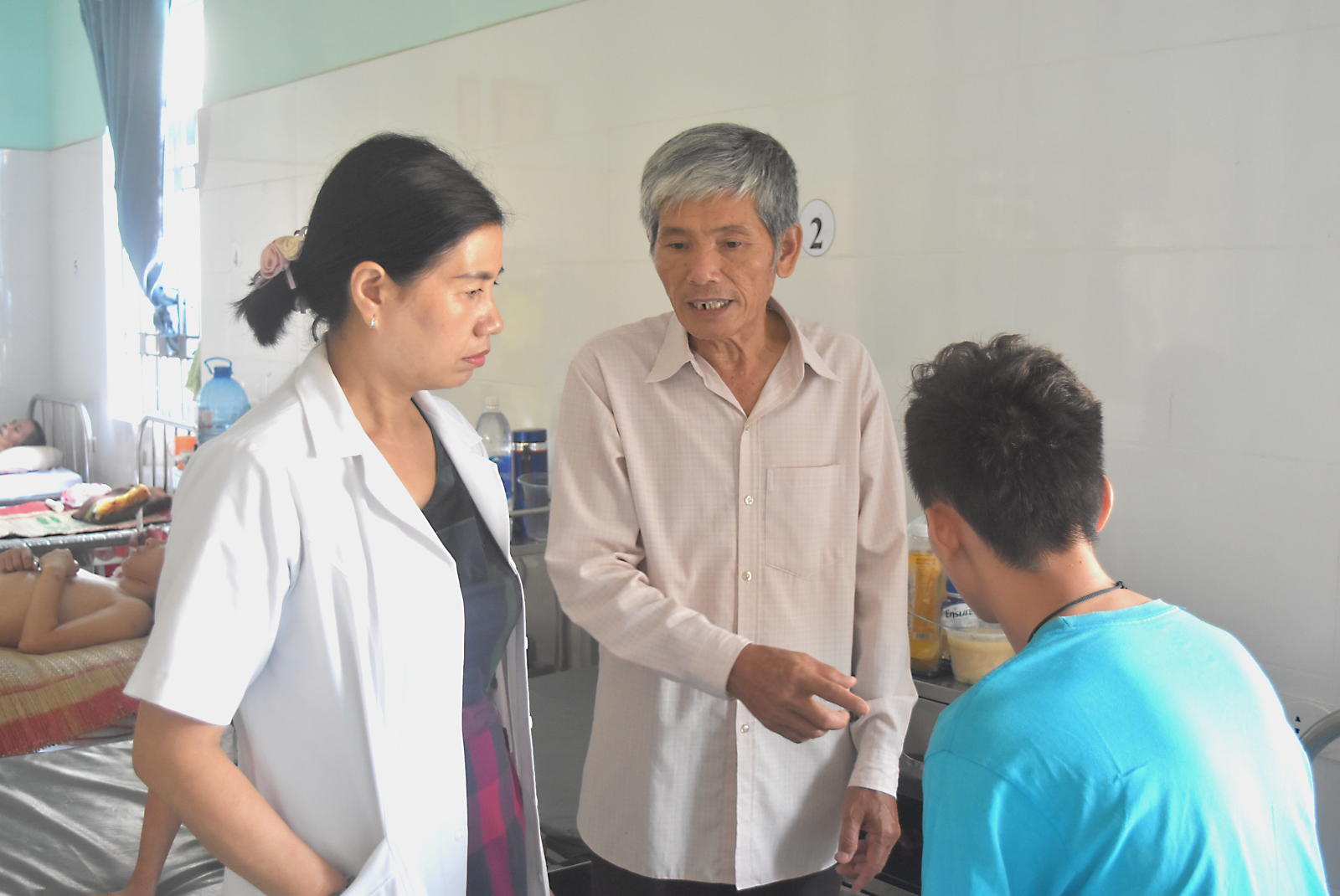 Bác sĩ Nguyễn Thị Bé thăm khám và tư vấn cho người nhà bệnh nhân cách chăm sóc bệnh nhân tâm thần trong những ngày nắng nóng.