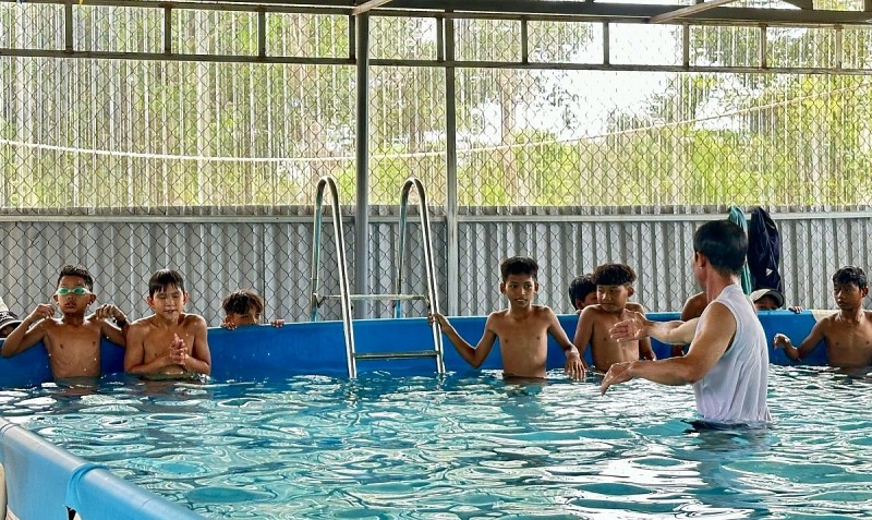 Các em học sinh tham gia lớp học bơi miễn phí trong dịp hè. Ảnh: Hương Lý