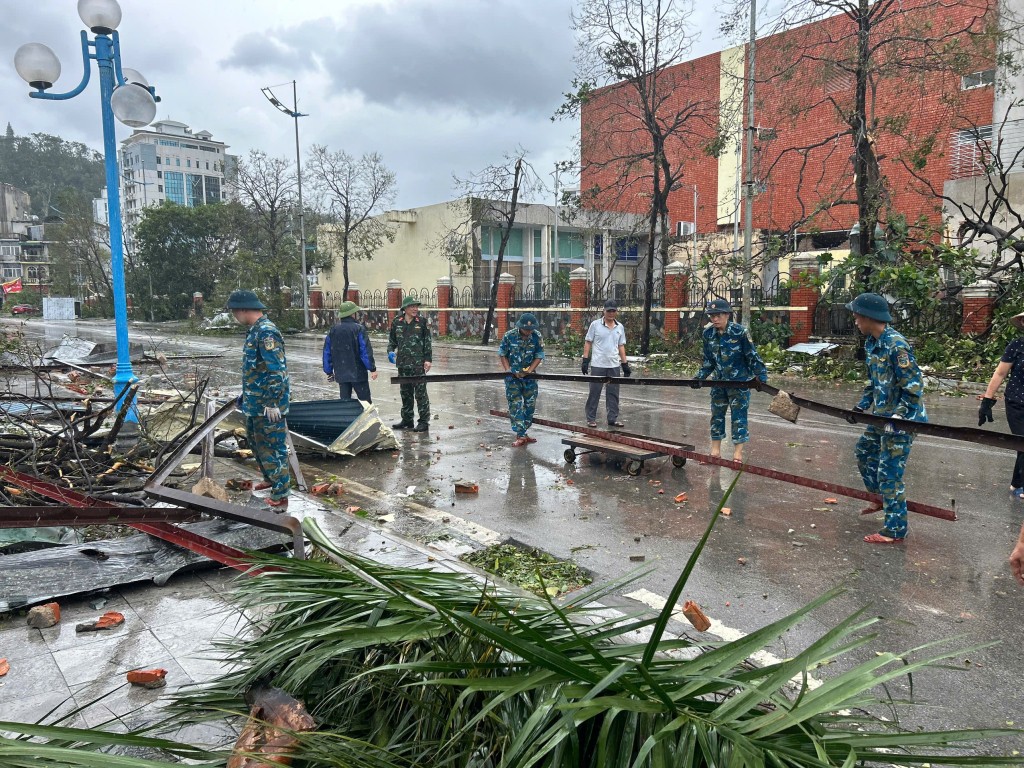 Cán bộ chiến sĩ Trung đoàn 213 tham gia hỗ trợ các cơ quan, người dân thu dọn vệ sinh, cây gãy đổ sau cơn bão số 3.