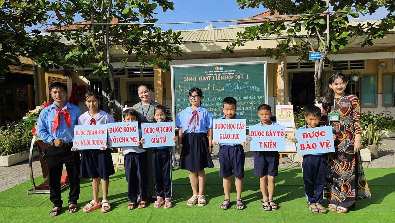 Giáo viên và học sinh Trường Tiểu học Phước Thạnh, TP Thủ Đức tuyên truyền, phổ biến các quyền cơ bản của trẻ em trong một chuyên đề sinh hoạt dưới cờ.