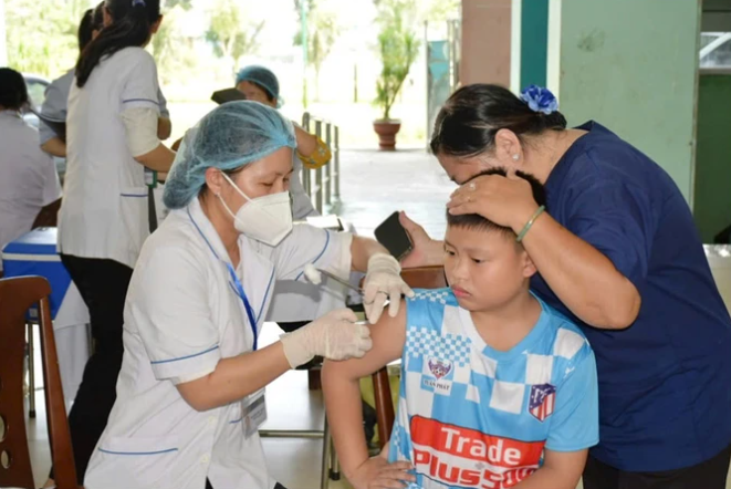 Nhân viên y tế tiêm vaccine cho trẻ.